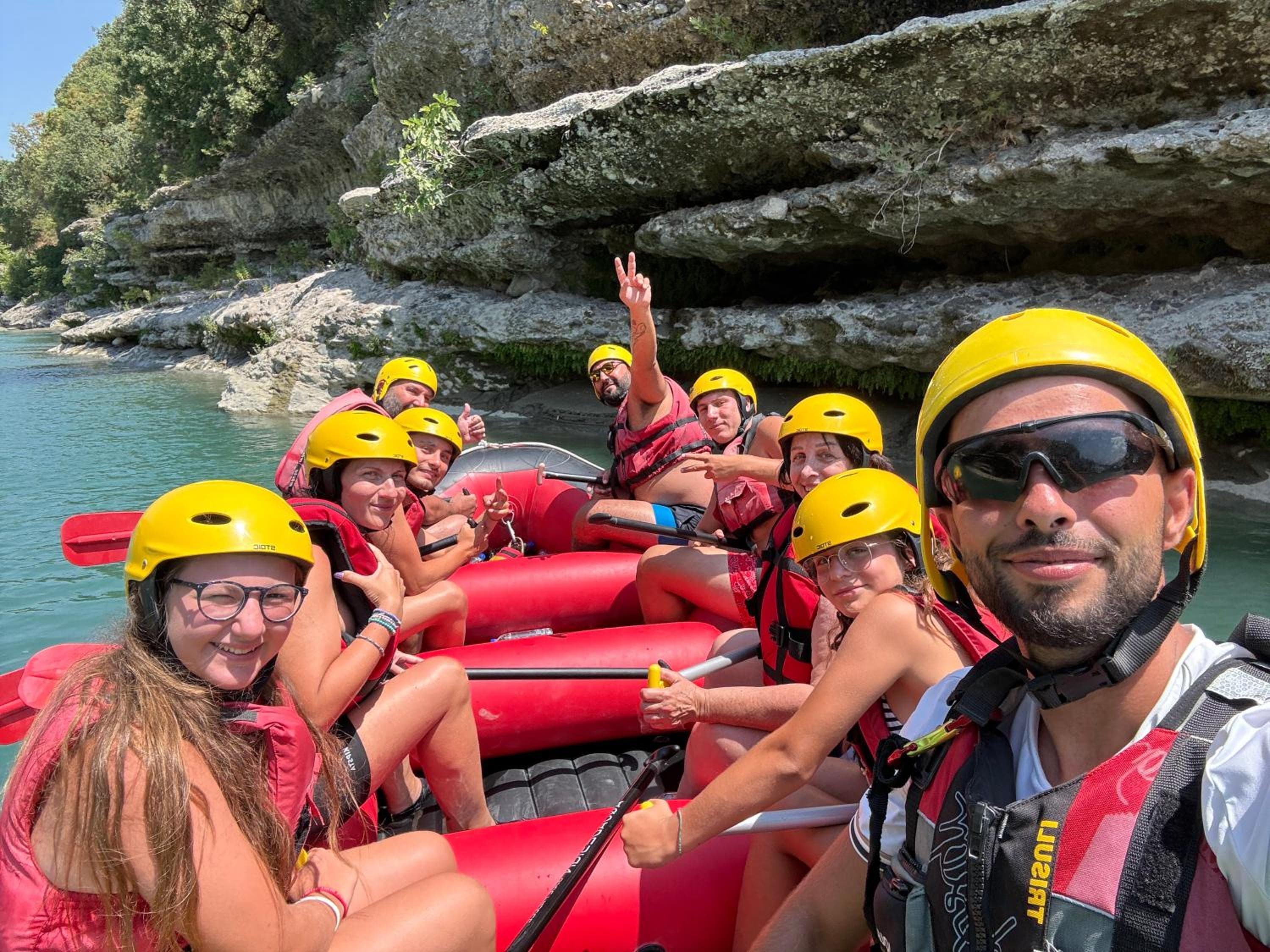 The crew in the raft under the canyon wall