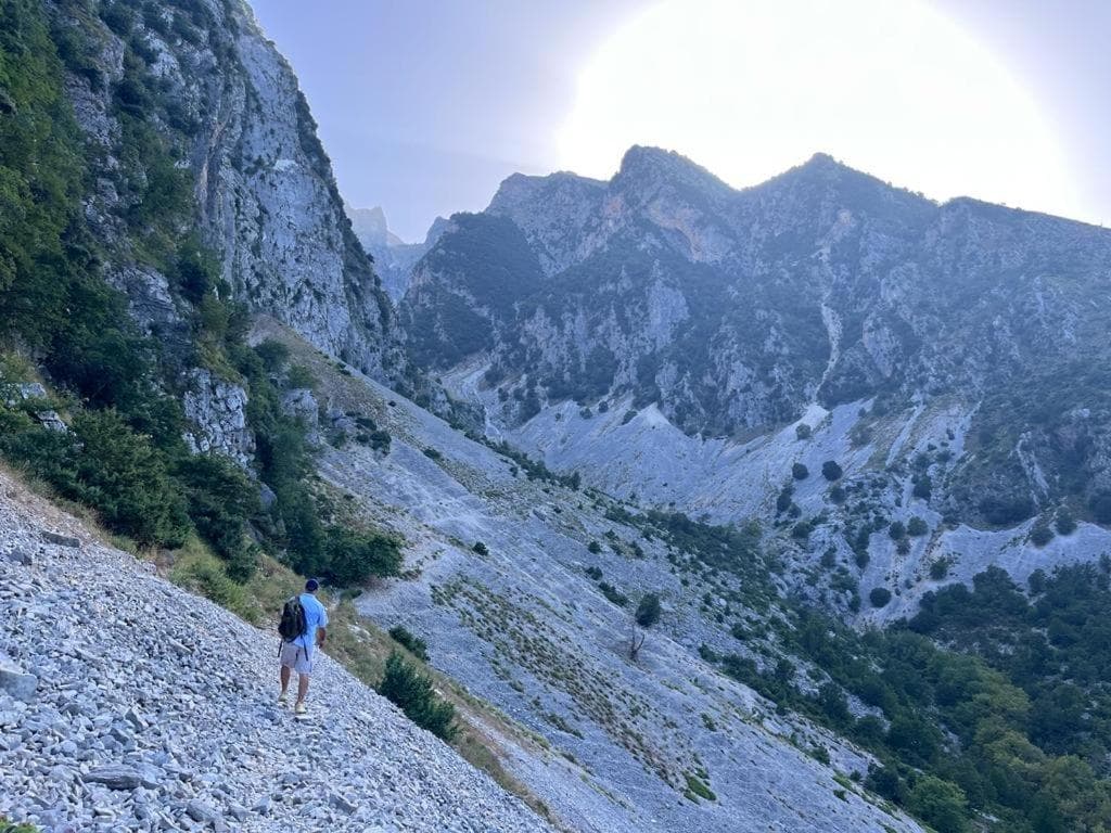 A walker crossing the scree below the peak
