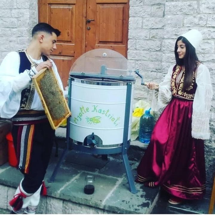 Extracting honey in traditional dress