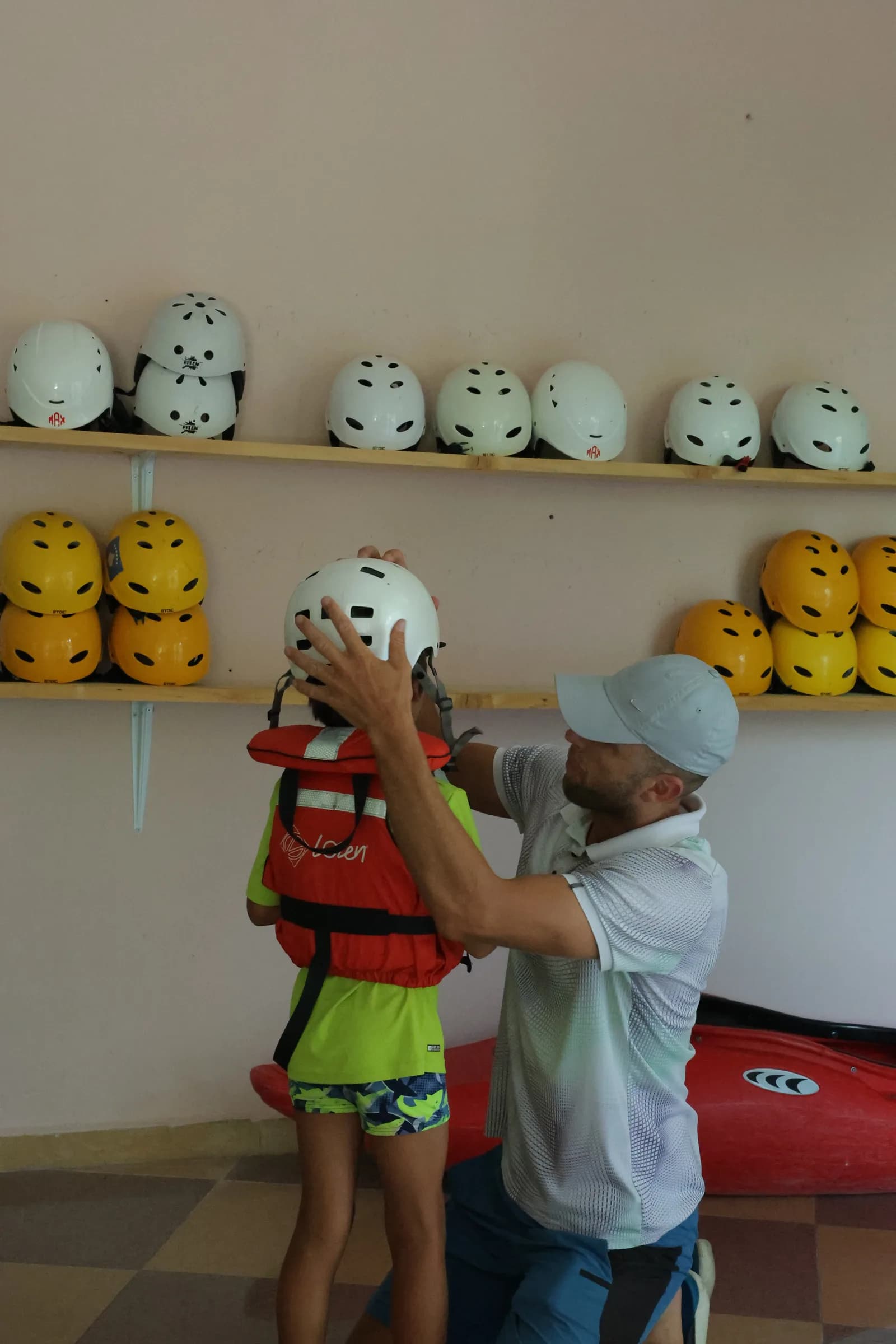 A guide fitting a child's helmet before the trip